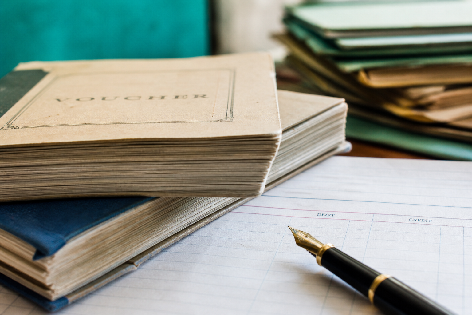 Voucher books and pen on an accounting desk